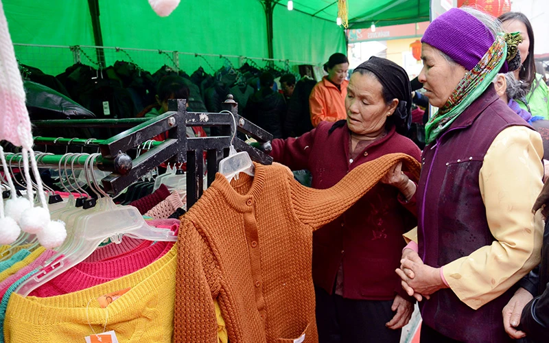 Người tiêu dùng lựa chọn các sản phẩm tại Phiên chợ đưa hàng Việt về nông thôn tại huyện Ứng Hòa (Hà Nội). Ảnh: MINH HÀ