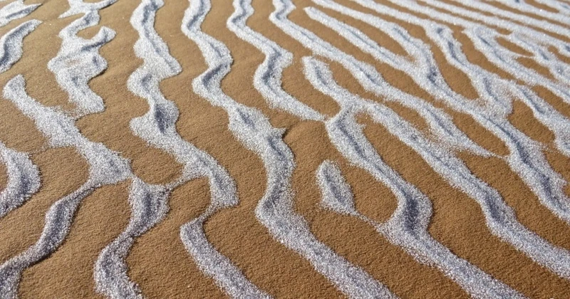 Tuyết để lại những họa tiết lạ thường trên cồn cát ở sa mạc Sahara. Ảnh: Bav Media