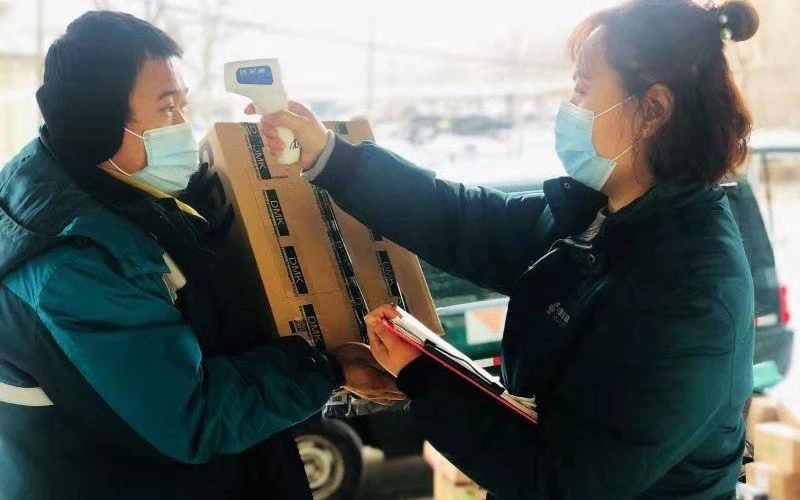 Nhân viên bưu điện Đại Hưng kiểm tra thân nhiệt trước khi giao hàng. 
