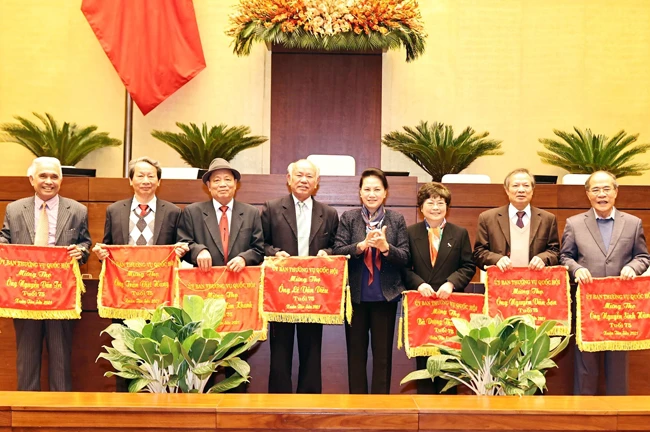 Chủ tịch QH Nguyễn Thị Kim Ngân trao bức trướng mừng thọ 75 tuổi tặng nguyên Chủ tịch QH Nguyễn Sinh Hùng và các đại biểu tại buổi gặp mặt. Ảnh: TRỌNG ĐỨC (TTXVN)