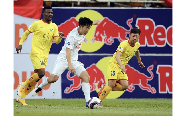 Pha tranh bóng giữa cầu thủ hai đội Hoàng Anh Gia Lai (áo trắng) và Sông Lam Nghệ An. Ảnh: VPF