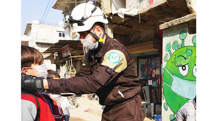 Lực lượng "Mũ trắng" phát khẩu trang cho người dân Syria. Ảnh: THE GUARDIAN