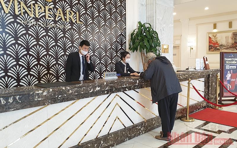 Nhân viên khách sạn hướng dẫn du khách khai Tờ khai y tế theo quy định phòng, chống dịch của Bộ Y tế (Ảnh: TRANG LINH)