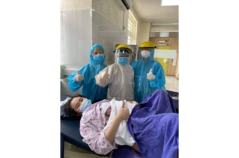 Ê kíp y, bác sĩ của Bệnh viện Sản nhi Quảng Ninh chung niềm vui với sản phụ Nguyễn Thị Hồng L.