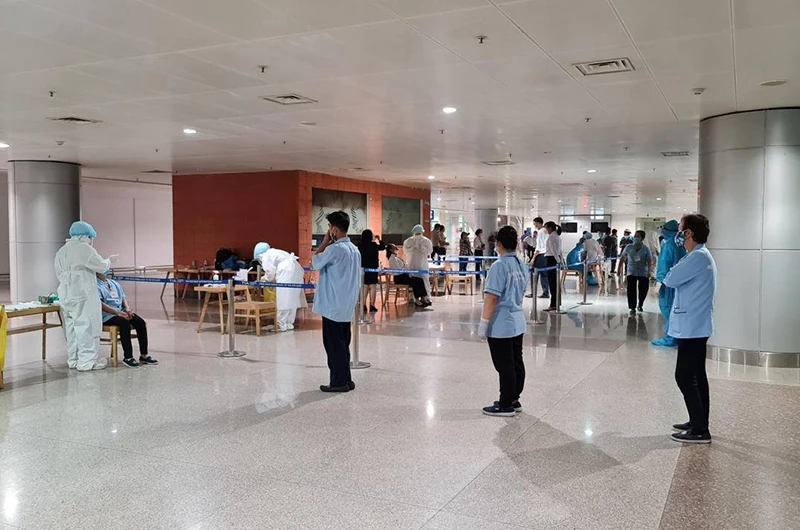 Lấy mẫu xét nghiệm nhân viên làm việc tại sân bay Tân Sơn Nhất. (Ảnh HCDC)