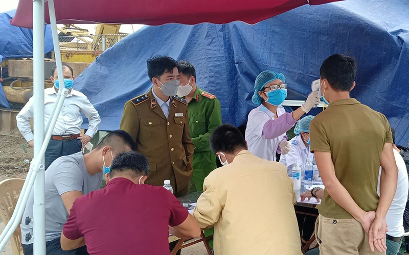 Khai báo y tế, kiểm tra thân nhiệt công dân tại chốt kiểm kiểm dịch cầu sông Hóa, tỉnh Thái Bình.