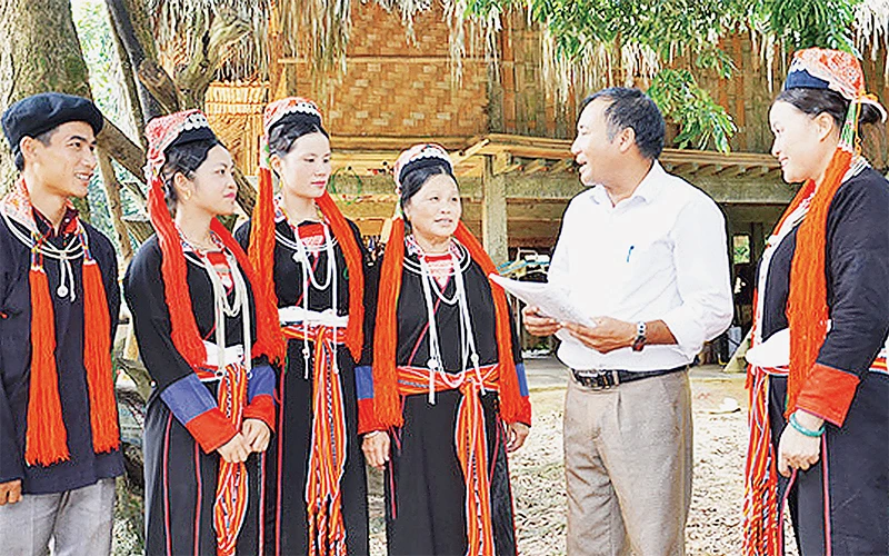 Tuyên truyền viên xã Chiêu Yên (huyện Yên Sơn, tỉnh Tuyên Quang) giải thích chính sách pháp luật cho bà con người dân tộc Dao thôn Tân Lập. Ảnh: TRANG TÂM