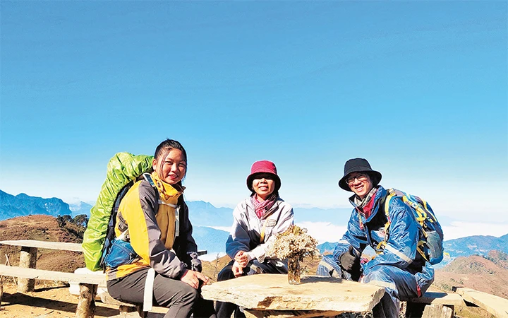 Lù Thị Gôn (trái) chụp ảnh cùng du khách trong chuyến leo núi Lảo Thẩn. Ảnh: K.H