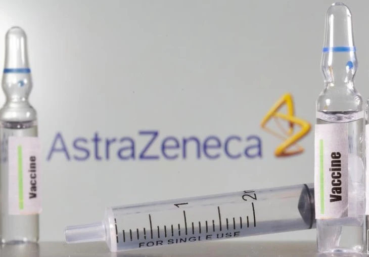 Lọ vaccine phía trước logo AstraZeneca. Ảnh: Reuters.
