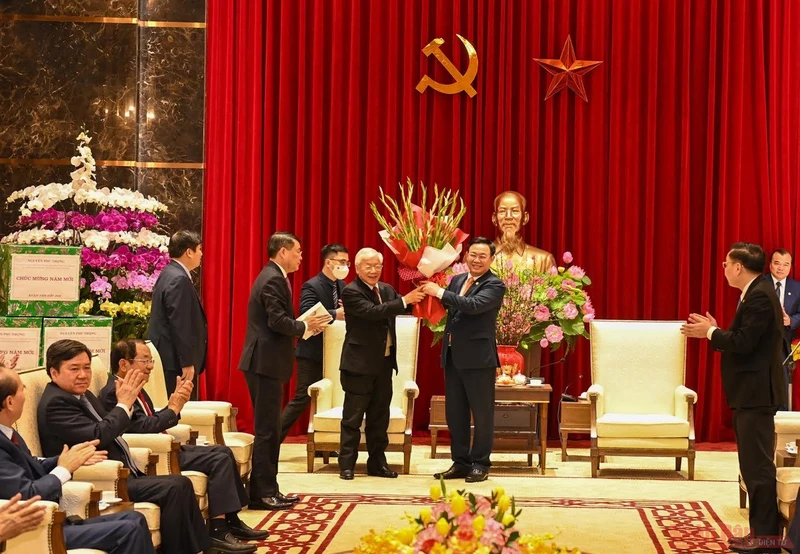 Bí thư Thành ủy Vương Đình Huệ tặng hoa chúc mừng Tổng Bí thư, Chủ tịch nước Nguyễn Phú Trọng. (Ảnh: DUY LINH)