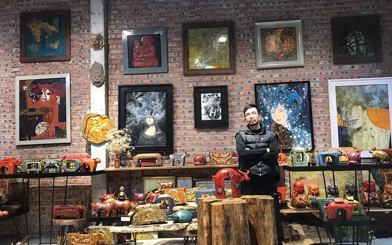 Nghệ nhân Nguyễn Tấn Phát bên những sản phẩm tượng trâu sơn mài.