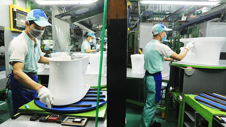 Công nhân Công ty TNHH Toto Việt Nam (tại Khu công nghiệp Thăng Long, huyện Đông Anh, Hà Nội) được trang bị khẩu trang khi làm việc.