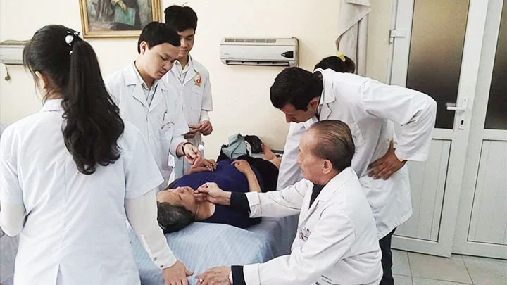 GS Nguyễn Tài Thu cùng các y, bác sĩ châm cứu cho bệnh nhân.