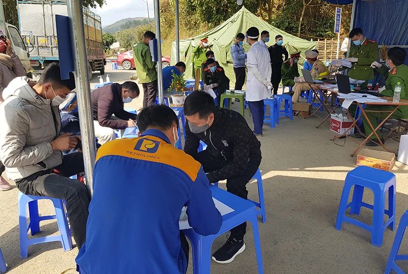 Người dân làm thủ tục khai báo y tế tại chốt kiểm soát phòng, chống dịch Covid-19 dưới chân đèo Pha Đin (địa phận huyện Tuần Giáo, tỉnh Điện Biên).