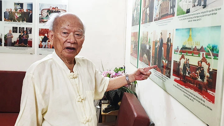 Thiếu tướng Huỳnh Đắc Hương giới thiệu những bức ảnh ghi lại các chuyến đi thăm lại đất nước Lào của mình. Ảnh: QĐND