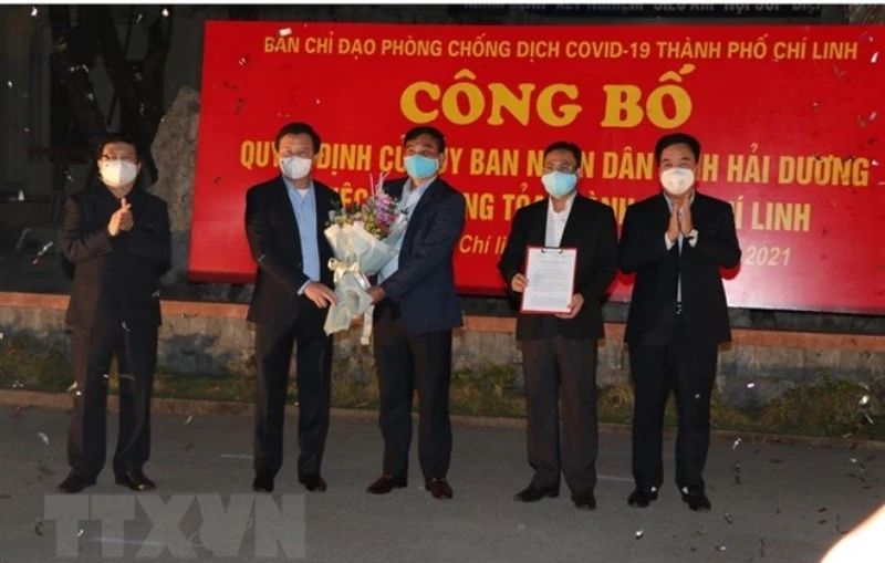 Lãnh đạo tỉnh Hải Dương trao quyết định của UBND tỉnh về gỡ bỏ phong tỏa TP Chí Linh. (Ảnh: TTXVN)