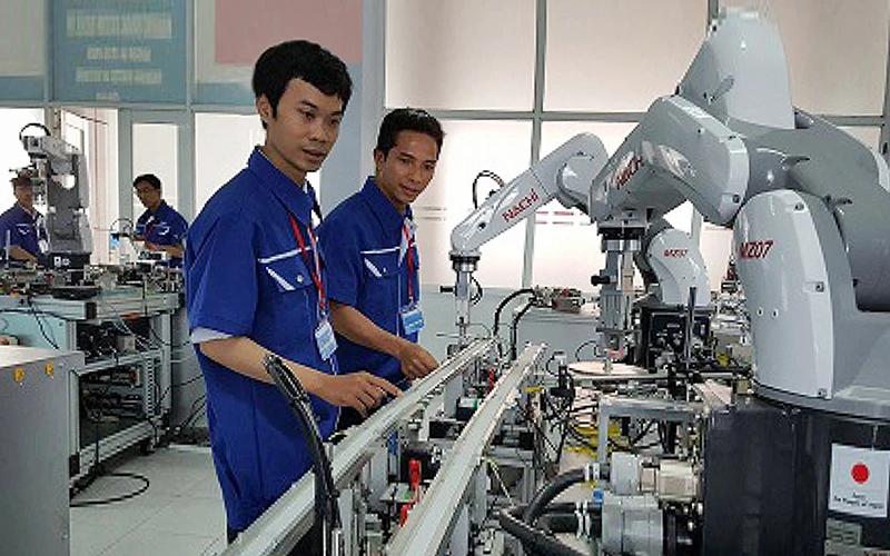 Các học viên vận hành rô-bốt tại Trung tâm Đào tạo và Chuyển giao công nghệ Việt Nhật thuộc Khu công nghệ cao TP Hồ Chí Minh. Ảnh: HÀ THẾ AN