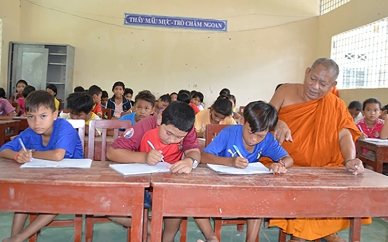 Thượng tọa Tăng Sa Vông, trụ trì chùa Cái Giá ở xã Hưng Hội, huyện Vĩnh Lợi dạy chữ cho học sinh dân tộc Khmer.