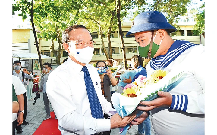 Đồng chí Nguyễn Văn Nên, Ủy viên Bộ Chính trị, Bí thư T.Ư Đảng, Bí thư Thành ủy TP Hồ Chí Minh trao hoa tặng tân binh tại điểm giao quân (quận 5).