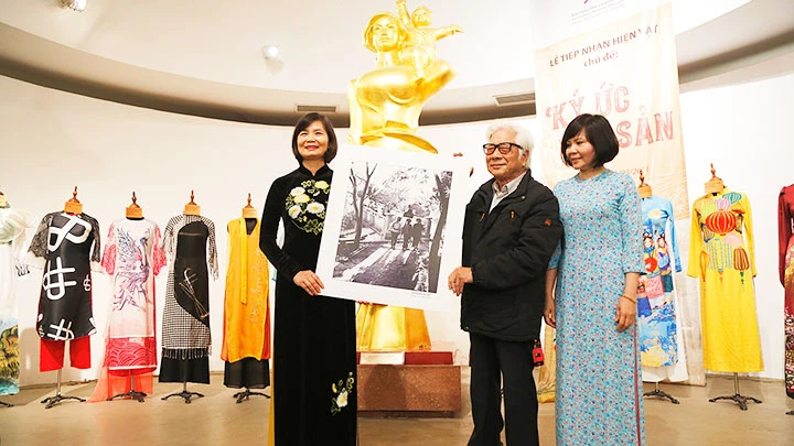 NSNA Đinh Quang Thành trao tặng các tác phẩm ảnh về đề tài phụ nữ cho đại diện Bảo tàng Phụ nữ Việt Nam.