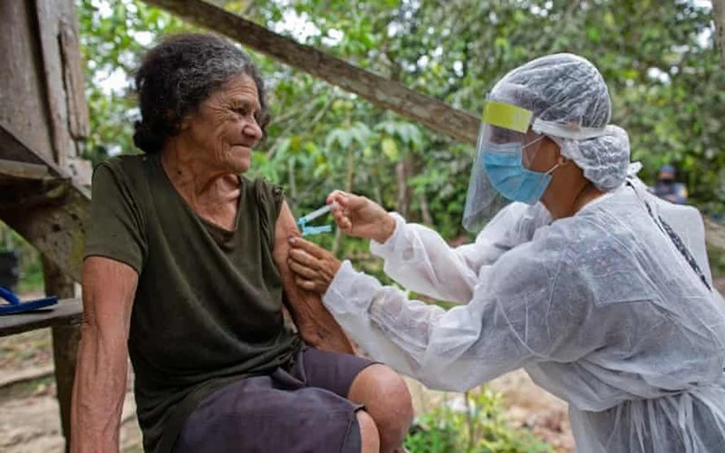 Nhân viên y tế tiêm vaccine ngừa Covid-19 cho bà Maria Ferreira (74 tuổi, Brazil). (Ảnh: Getty Images)