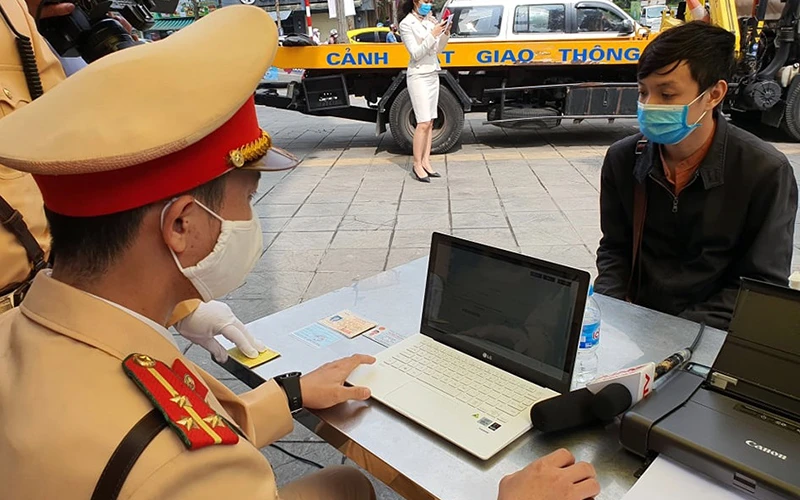 Cán bộ Ðội Cảnh sát giao thông số 2 (Công an TP Hà Nội) tiến hành xử phạt "online" đối với người vi phạm thông qua cơ sở dữ liệu quốc gia về dân cư. 
