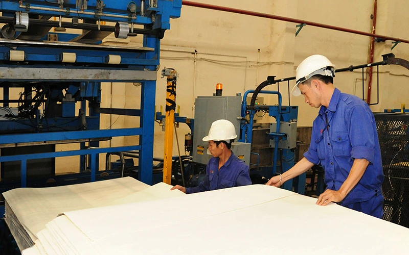 Công nhân Công ty cổ phần giấy An Hòa, huyện Sơn Dương (Tuyên Quang) vận hành dây chuyền sản xuất giấy xuất khẩu. Ảnh: TRẦN HẢI
