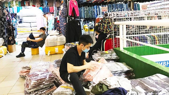 Người Việt Nam tại chợ Liu chấp hành quy định đeo khẩu trang phòng dịch.