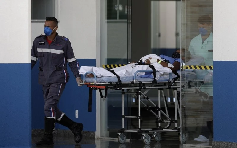 Nhân viên y tế đưa người nghi mắc Covid-19 tới bệnh viện dã chiến Luziania, Brazil, ngày 25-2. (Ảnh: AP)