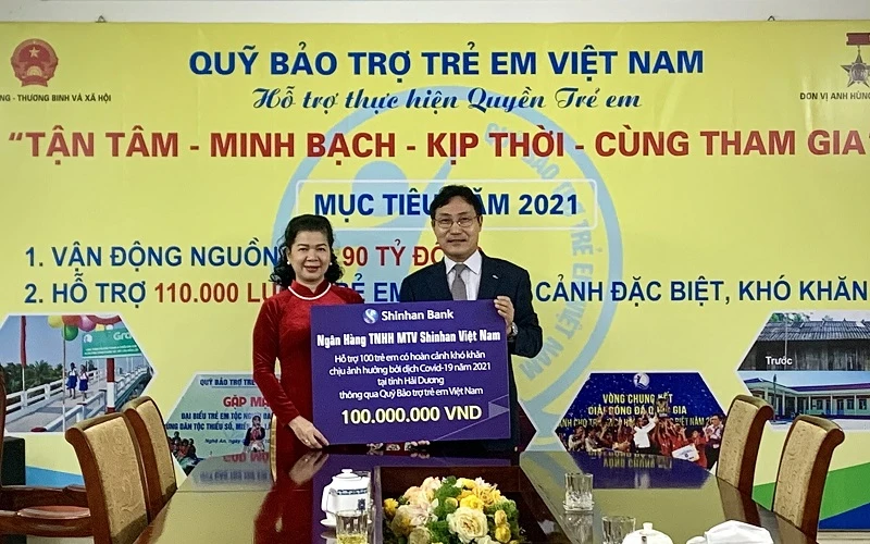 Bà Lê Tuyết Mai, Phó Giám đốc Quỹ Bảo trợ Trẻ em Việt Nam nhận tượng trưng số tiền hỗ trợ cho trẻ em Hải Dương từ ông Cho Mun Sung, Phó Tổng Giám đốc Shinhan Việt Nam.