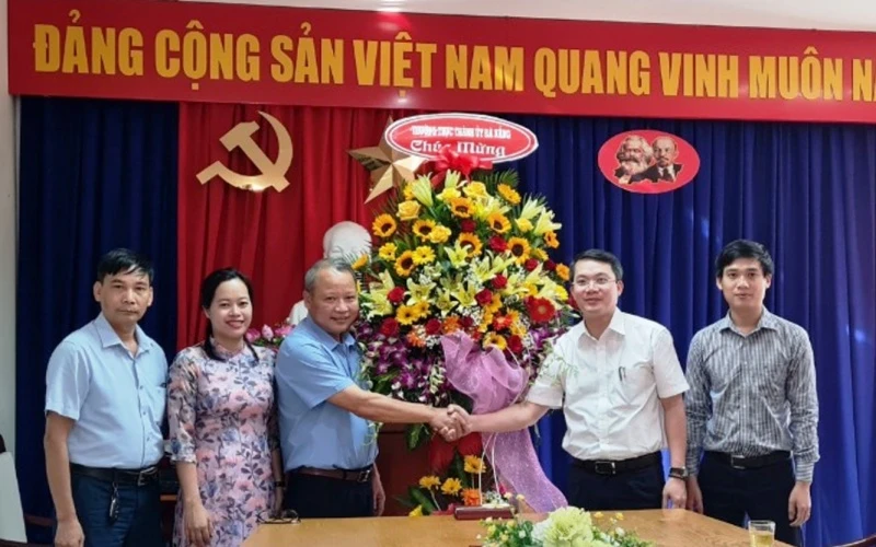 Đại diện Thường trực Thành ủy tặng hoa chúc mừng ngày Báo Nhân Dân ra số đầu.