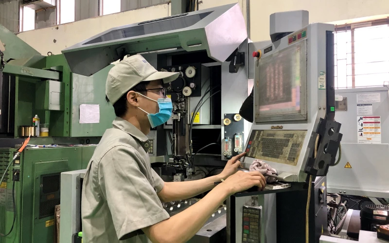 Công nhân tại Công ty TNHH SX và DVTM Kim Long (Cụm công nghiệp Từ Liêm, Hà Nội) vận hành hệ thống sản xuất tự động qua máy tính.