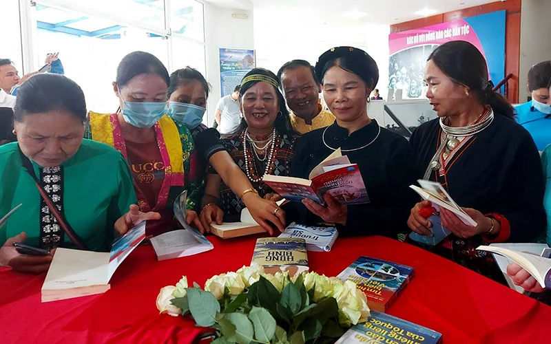 Ðồng bào các dân tộc tìm đọc các tác phẩm văn học về chủ đề biển đảo tại Làng Văn hóa - Du lịch các dân tộc Việt Nam. Ảnh: Mai Lữ