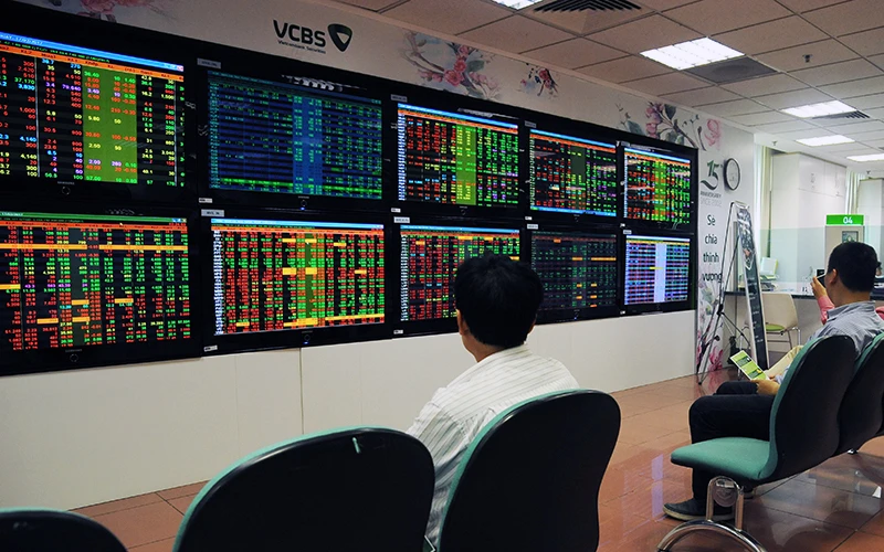 Khách hàng theo dõi bảng giao dịch chứng khoán tại sàn giao dịch Vietcombank (VCBS). Ảnh: Phạm Hưng 