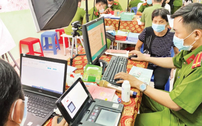 Cán bộ công an hỗ trợ người dân làm thẻ căn cước công dân có gắn chíp tại Nhà văn hóa liên phường Bình Trị Đông, quận Bình Tân.