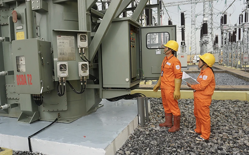 Công nhân Tổng công ty Ðiện lực TP Hà Nội kiểm tra thông số vận hành thiết bị trạm biến áp 110 kV, bảo đảm cung cấp điện an toàn, ổn định cho Thủ đô. Ảnh: BẢO TÙNG