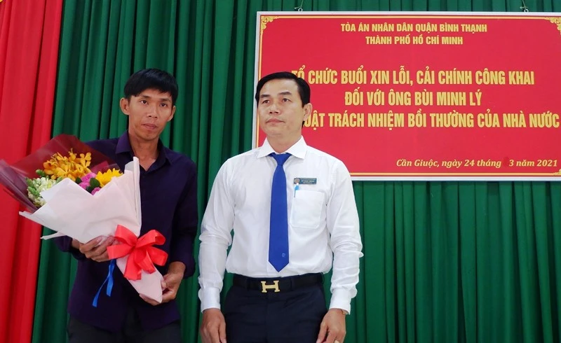 Phó Chánh án TAND quận Bình Thạnh (TP Hồ Chí Minh) Vũ Ngọc Hoan tặng hoa cho anh Lý.