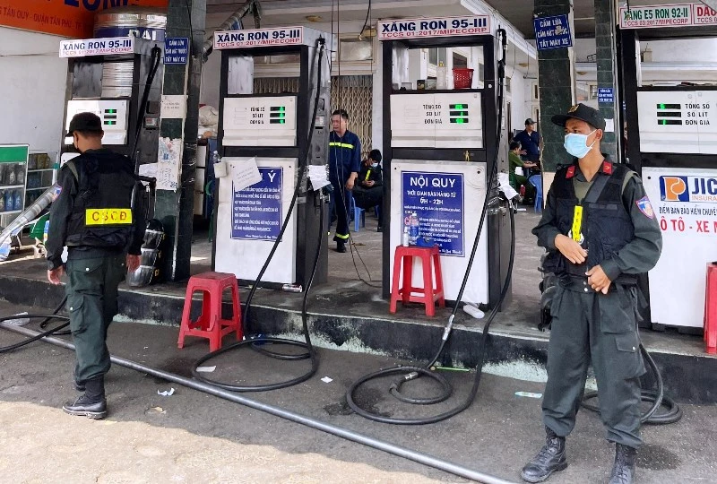 Cảnh sát cơ động bảo vệ hiện trường việc khám xét cây xăng doanh nghiệp tư nhân xăng dầu Bình Long.