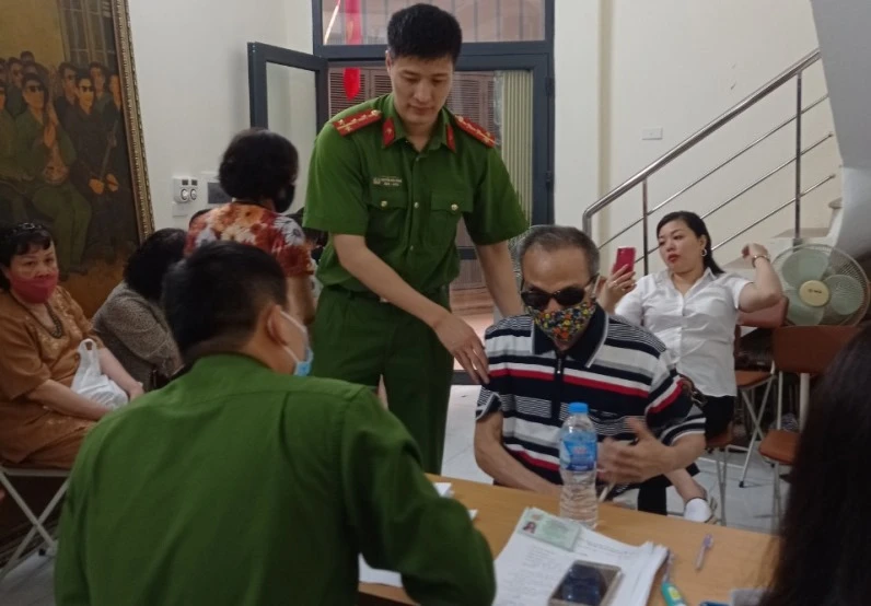 Đội Cảnh sát QLHC về TTXH Công an quận Ba Đình hỗ trợ ông Đinh Phương Thi là thương binh hỏng mắt, làm thủ tục cấp CCCD mới.