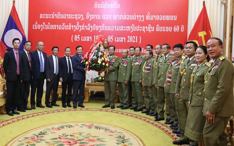 Trung tướng Kongthong Phongvichit vui mừng đón nhận những lẵng hoa tươi thắm, đầy tình hữu nghị tại buổi tiếp, ngày 2-4.
