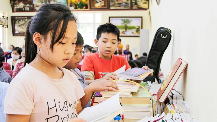 Các em nhỏ trải nghiệm tủ sách miễn phí ở điểm đọc mới của thư viện Hồng Châu tại Nhà văn hóa tổ dân phố Hoàng Lê.