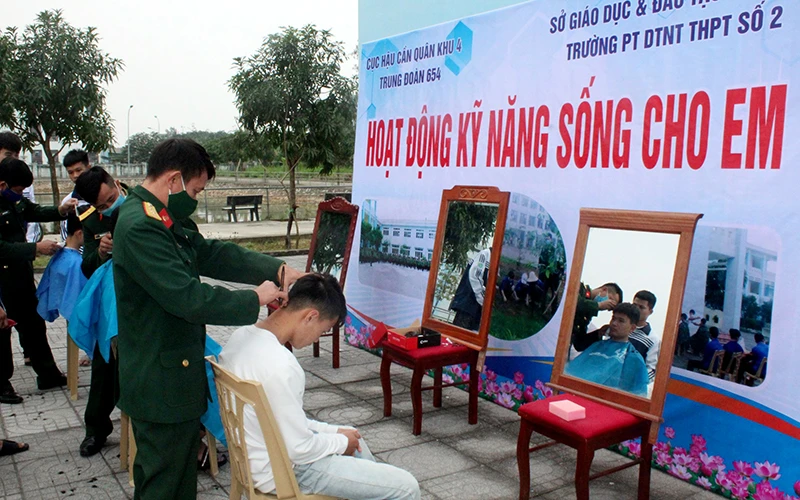 Cán bộ, chiến sĩ Trung đoàn 654 cắt tóc cho học sinh Trường dân tộc nội trú THPT số 2 tỉnh Nghệ An.