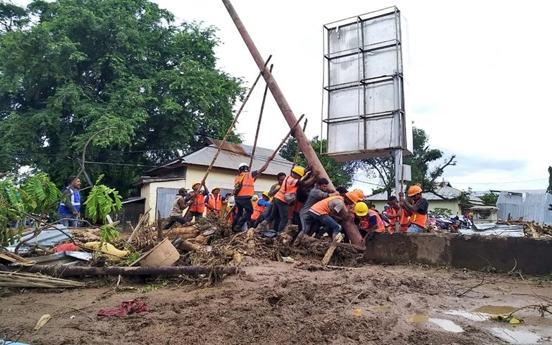 Lực lượng cứu nạn nối lại đường điện tại khu vực bị ngập lụt trên đảo Adonara, phía đông Indonesia, ngày 6-4. (Ảnh: AP)