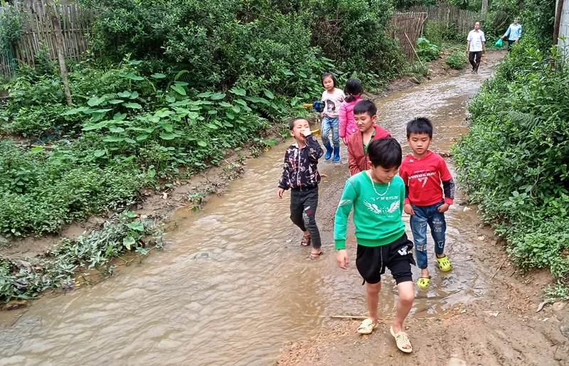 Con em xóm Tân Kim thường xuyên phải đi dọc dưới dòng suối ô nhiễm.