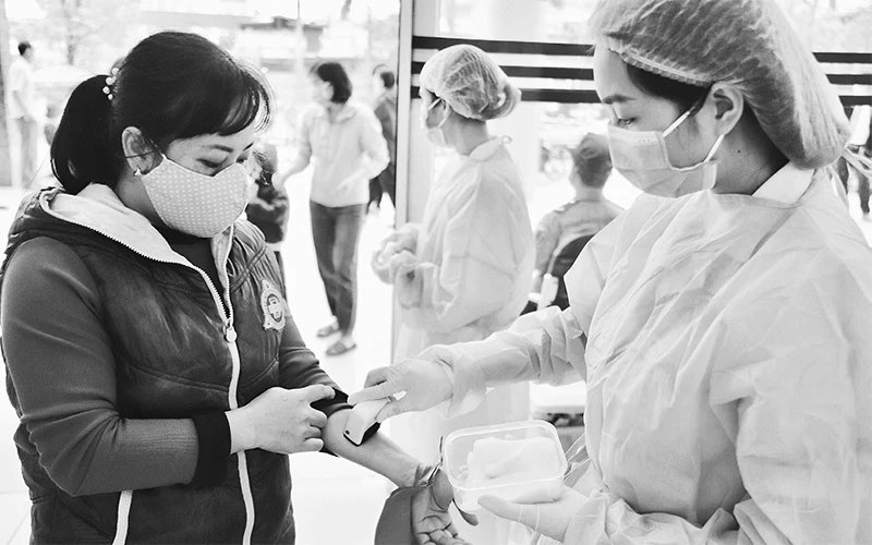 Nhân viên y tế Bệnh viện K kiểm tra, giám sát người ra - vào bệnh viện để phòng, chống dịch Covid-19.