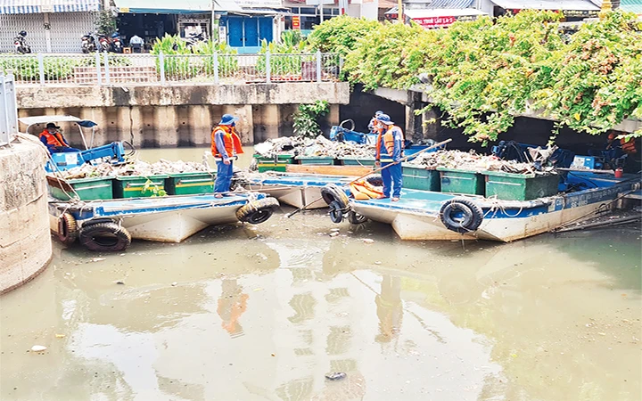 Công nhân Công ty Môi trường đô thị TP Hồ Chí Minh thu gom cá chết trên kênh Nhiêu Lộc - Thị Nghè.