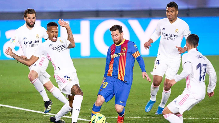 Lionel Messi (áo sẫm) cô độc giữa vòng vây của các cầu thủ Real Madrid.