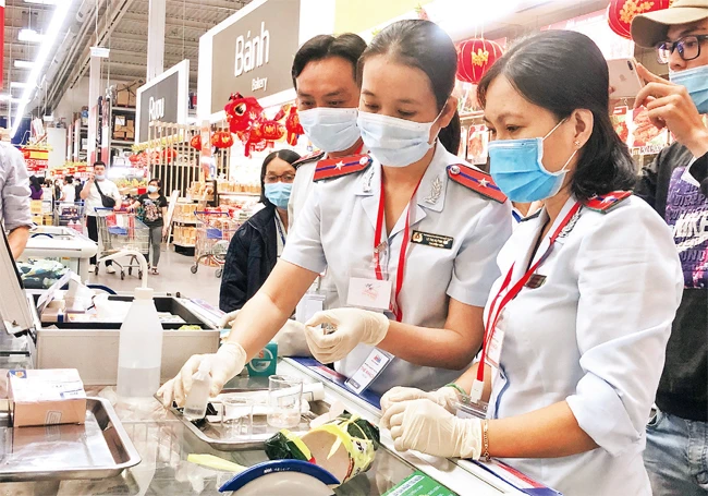 Cán bộ Ban quản lý An toàn thực phẩm TP Hồ Chí Minh lấy mẫu kiểm tra nhanh thực phẩm tại siêu thị.
