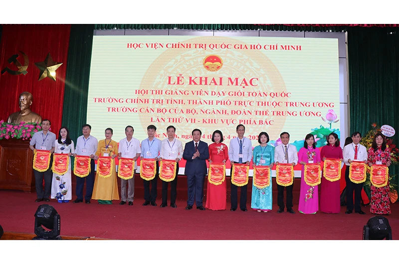 Đồng chí Nguyễn Xuân Thắng, Ủy viên Bộ Chính trị, Giám đốc Học viện Chính trị quốc gia Hồ Chí Minh trao cờ lưu niệm cho các đoàn thi.