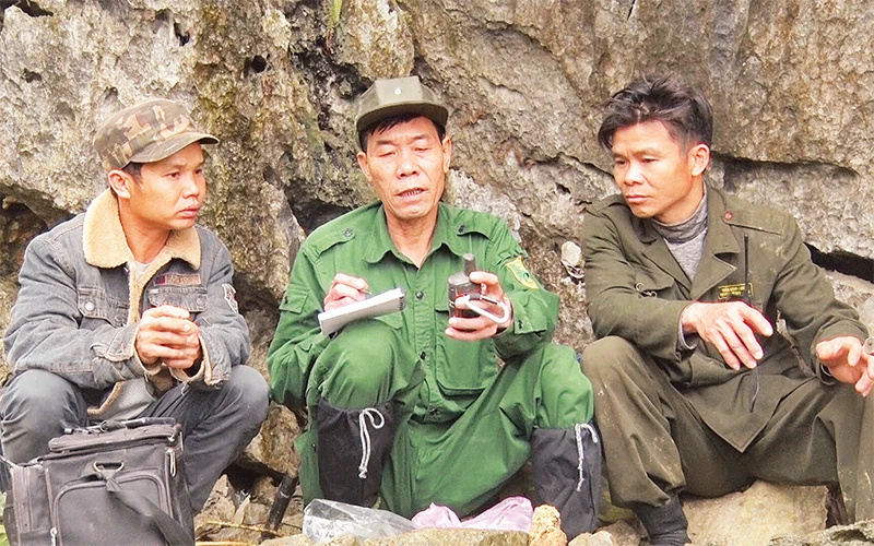 Ông Lê Văn Hiên (ngồi giữa) cùng các thành viên Tổ Bảo tồn cộng đồng ghi chép số liệu theo dõi voọc mông trắng sinh sống trong rừng Thanh Sơn.